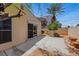 This backyard features a tree, a block wall, and a concrete patio with desert landscaping at 100 Woolman Rink Ave, Las Vegas, NV 89123