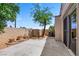 This backyard features a tree, a block wall, and a concrete patio with a sliding door at 100 Woolman Rink Ave, Las Vegas, NV 89123