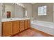 Bathroom featuring dual sinks, a large mirror, and a soaking tub at 100 Woolman Rink Ave, Las Vegas, NV 89123