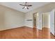 A bright bedroom featuring hardwood floors, a ceiling fan, and an open doorway at 100 Woolman Rink Ave, Las Vegas, NV 89123