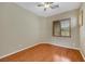 This bedroom features hardwood floors, a ceiling fan, and a window with wooden blinds at 100 Woolman Rink Ave, Las Vegas, NV 89123