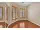 This bedroom features hardwood floors, a mirrored closet, and two windows with wooden blinds at 100 Woolman Rink Ave, Las Vegas, NV 89123