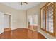 This bedroom features hardwood floors, a mirrored closet, a window with wooden blinds, and an exit door at 100 Woolman Rink Ave, Las Vegas, NV 89123