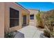 Side entrance view of a neutral single Gathering home with landscaped features and shade from a nearby bush at 100 Woolman Rink Ave, Las Vegas, NV 89123