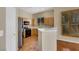 Well-lit kitchen featuring tiled flooring, maple cabinetry, stainless steel appliances and a window overlooking a green space at 100 Woolman Rink Ave, Las Vegas, NV 89123