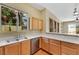 Bright kitchen featuring maple cabinetry, stainless steel appliances, tiled floor and a pass-through to the living room at 100 Woolman Rink Ave, Las Vegas, NV 89123