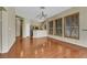 Open floor plan with wood floors, neutral walls, and view of the kitchen and windows with custom shutters at 100 Woolman Rink Ave, Las Vegas, NV 89123