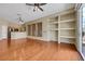 Open-concept living room boasts hardwood floors, built-in shelving, shuttered windows, and access to the kitchen at 100 Woolman Rink Ave, Las Vegas, NV 89123