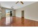 Spacious living room featuring wood floors, a ceiling fan, neutral walls, a patio door, and built in shelving at 100 Woolman Rink Ave, Las Vegas, NV 89123