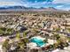 An aerial view of the community showcasing homes, palm trees, and a pool area against a mountain backdrop at 10205 Birch Bluff Ln, Las Vegas, NV 89145
