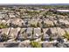 Community aerial view of houses with dark roofs, mature trees, and a community pool area at 10205 Birch Bluff Ln, Las Vegas, NV 89145