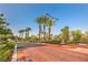 Community entrance featuring lush landscaping, palm trees and decorative brickwork at 10205 Birch Bluff Ln, Las Vegas, NV 89145