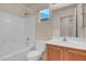Bright bathroom featuring shower and tub, toilet, and a wood vanity with white countertop at 10630 Lunar Crest Ave, Las Vegas, NV 89129