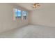 Bright bedroom featuring tile floors, neutral paint, ceiling fan, and dual windows letting in plenty of natural light at 10630 Lunar Crest Ave, Las Vegas, NV 89129