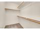 Walk-in closet showing neutral carpet and white walls with wood shelving rods at 10630 Lunar Crest Ave, Las Vegas, NV 89129