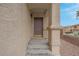 Covered entryway with textured walls and a dark-stained front door at 10630 Lunar Crest Ave, Las Vegas, NV 89129