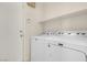 Laundry room featuring modern washer and dryer with a storage shelf at 10630 Lunar Crest Ave, Las Vegas, NV 89129