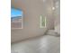 Bright, airy living room with tile floors, staircase, and multiple windows at 10630 Lunar Crest Ave, Las Vegas, NV 89129