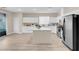 Modern kitchen featuring white cabinetry, stainless steel appliances, a center island, and light plank flooring at 11074 Caramel Crest Ct, Las Vegas, NV 89135