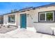 Close up of the home's entrance, with a blue door, manicured yard and upgraded windows at 1116 E Owens Ave, North Las Vegas, NV 89030