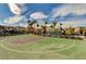 Outdoor basketball court with an attached playground, trees, and surrounding residential community at 12107 Frost Lime Rd # 1, Las Vegas, NV 89183