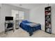 Well-lit bedroom with neutral carpet, a cozy blue bed, desk setup, and a tall bookcase for both studying and relaxing at 12107 Frost Lime Rd # 1, Las Vegas, NV 89183