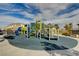 Community playground with green, blue, and gray equipment and safe fall flooring at 12107 Frost Lime Rd # 1, Las Vegas, NV 89183