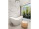 A luxurious bathroom featuring a freestanding tub and a garden view window with natural light at 13 Rockstream Dr, Henderson, NV 89012