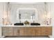 Luxury bathroom vanity with double sinks, wood cabinets and a large mirror with accent lighting at 13 Rockstream Dr, Henderson, NV 89012