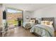 Bright bedroom featuring two twin beds, a large window with a desert view, and hardwood floors at 13 Rockstream Dr, Henderson, NV 89012