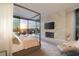 A modern bedroom boasts a fireplace and a view of the sunset over the outdoor seating area at 13 Rockstream Dr, Henderson, NV 89012