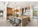 Stunning kitchen with a large marble island, pendant lighting, stainless steel appliances, and sleek wooden cabinets at 13 Rockstream Dr, Henderson, NV 89012