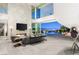 Modern living room boasting a fireplace, city views, and an open transition to the outdoor pool area at 13 Rockstream Dr, Henderson, NV 89012
