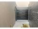 Modern outdoor shower featuring gray tile and pebble flooring, offering a luxurious open-air bathing experience at 13 Rockstream Dr, Henderson, NV 89012