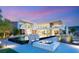 Modern home with a pool, hot tub, fire pit, and beautiful lighting, perfect for evening relaxation and gatherings at 13 Rockstream Dr, Henderson, NV 89012