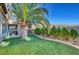 Spacious backyard with a well-manicured lawn, small trees, and covered patio at 1353 Volturno Way, Henderson, NV 89052
