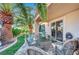 Cozy covered patio featuring wicker furniture and a view of the lush, landscaped backyard at 1353 Volturno Way, Henderson, NV 89052