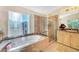 Bright bathroom featuring a separate shower and tub, with large windows bringing in natural light at 1353 Volturno Way, Henderson, NV 89052