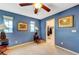 Cozy bedroom featuring a ceiling fan, blue walls and a walk in closet at 1353 Volturno Way, Henderson, NV 89052