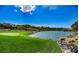 Picturesque golf course featuring a serene lake, manicured green grass, and elegant homes in the background at 1353 Volturno Way, Henderson, NV 89052