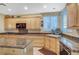 Bright kitchen featuring granite countertops, light wood cabinets and stainless steel appliances at 1353 Volturno Way, Henderson, NV 89052