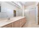 Bright bathroom featuring a double vanity, large mirror, and glass shower at 1781 Cypress Lake Ct, Henderson, NV 89012