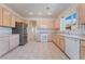 Well-lit kitchen showcasing stainless steel refrigerator, white cabinets, and tile flooring at 1781 Cypress Lake Ct, Henderson, NV 89012