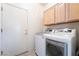 Well-equipped laundry room features wooden cabinets and modern washer and dryer at 1781 Cypress Lake Ct, Henderson, NV 89012