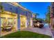 Backyard with covered patio, seating area with fire pit, lush lawn, and pool at dusk at 2008 Winter Wind St, Las Vegas, NV 89134