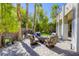 Outdoor seating with fire pit on brick patio surrounded by green vegetation and tall palm trees at 2008 Winter Wind St, Las Vegas, NV 89134