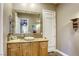 Bathroom featuring a stone-framed mirror, wooden vanity, and tiled countertop at 2008 Winter Wind St, Las Vegas, NV 89134
