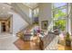 Bright, open living room with floor-to-ceiling windows, comfortable seating, and a grand staircase at 2008 Winter Wind St, Las Vegas, NV 89134