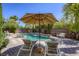 Inviting pool area with lounge chairs, shade umbrella, and lush greenery at 2008 Winter Wind St, Las Vegas, NV 89134
