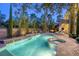 Tranquil backyard featuring a pool, spa, waterfall, lush landscaping, and outdoor seating at 2008 Winter Wind St, Las Vegas, NV 89134